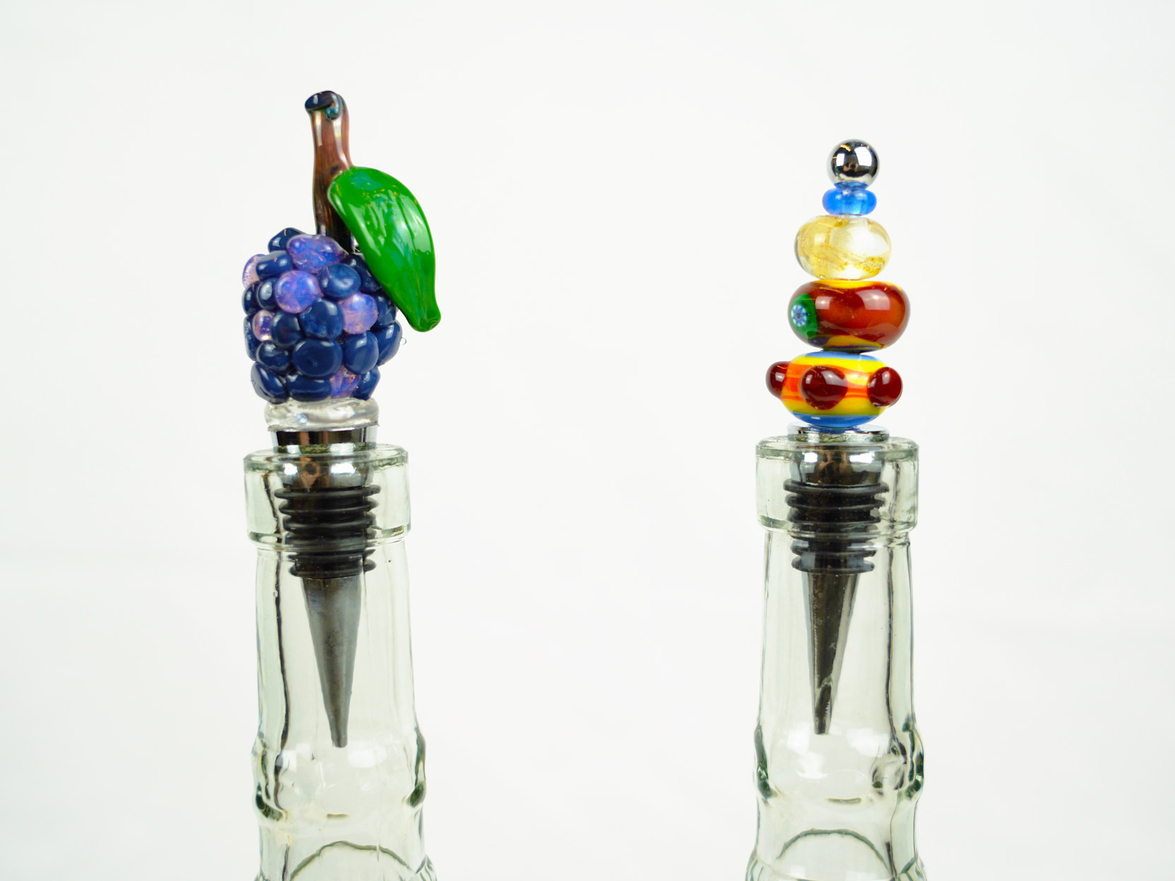 Photo of two glass bottle stoppers sitting in the top of two glass bottles.