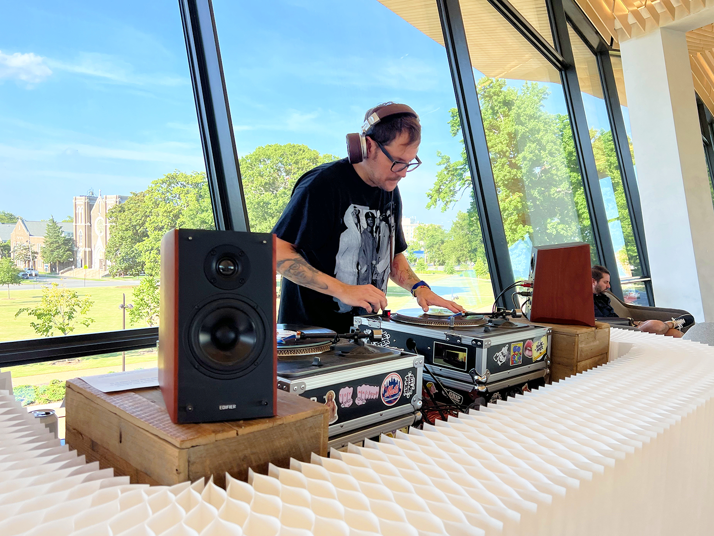 Photo of a male DJ behind a DJ booth in AMFA's Cultural Living Room.