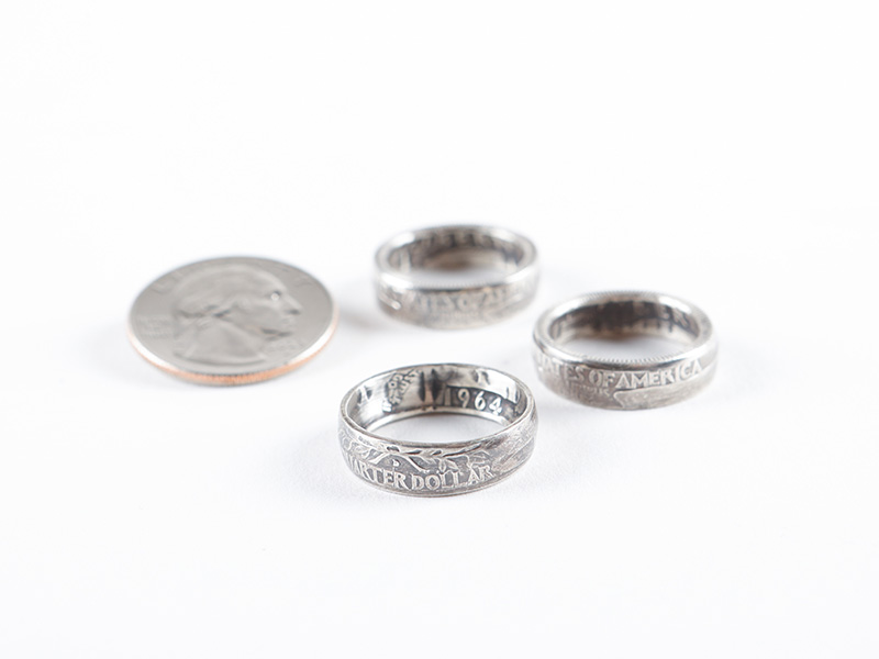 Photo of three coin rings sitting next to a quarter on a white background.