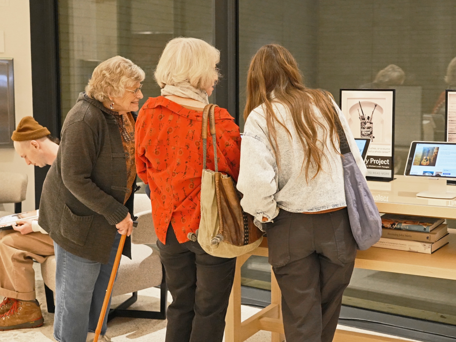 Photo of three women looking at stories on an iPad screen.
