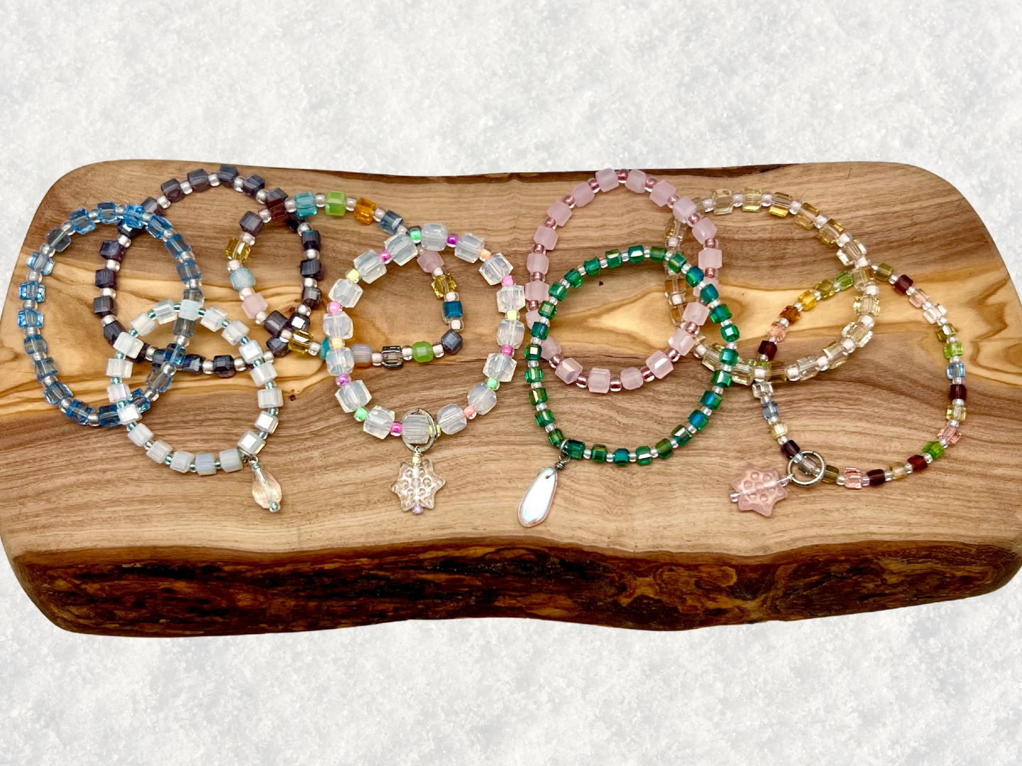 Photo of several bracelets on a wooden surface set on snow.