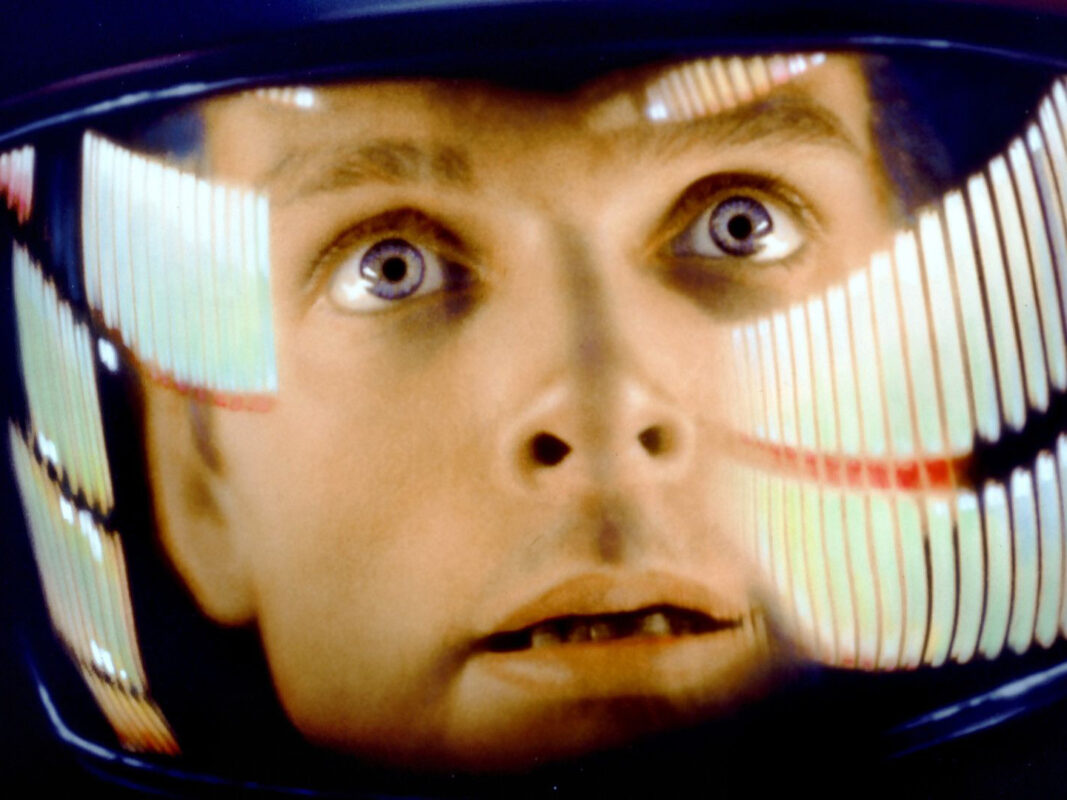 Film still from 2001 A Space Odyssey depicting a close-up shot of a man wearing a helmet.
