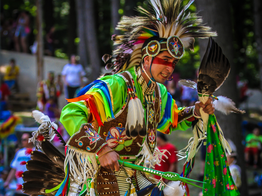 Photo of a Native American dancer dancing in traditional cultural attire.