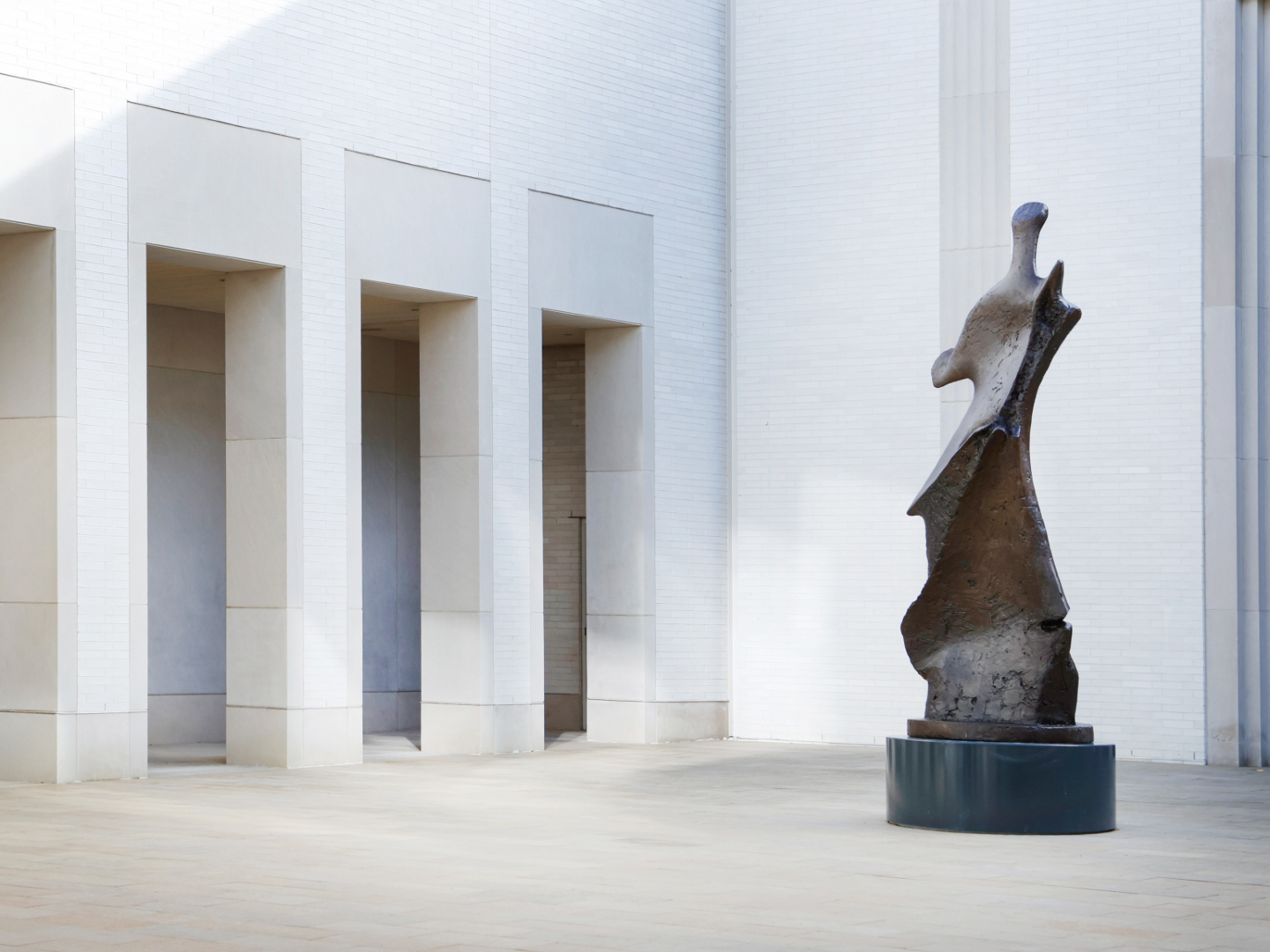Daytime photo of a bronze sculpture by Henry Moore at the Courtyard Entrance to AMFA.
