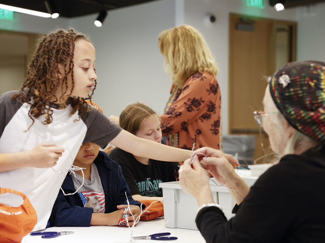 Photo of a children and adults making sculptures out of wire in an art studio in the Windgate Art School.