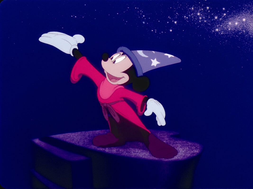 Film still from Fantasia depicting Mickey Mouse wearing a red cloak and sorcerer's hat.