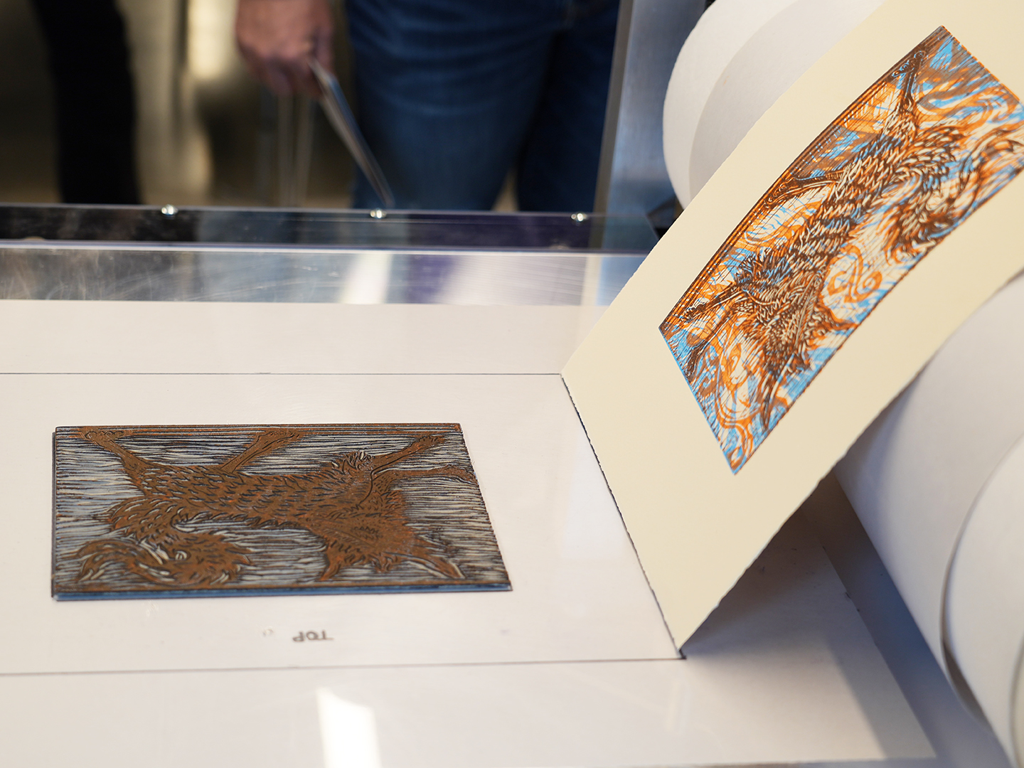 Photo of an abstract art print coming off a printing press.