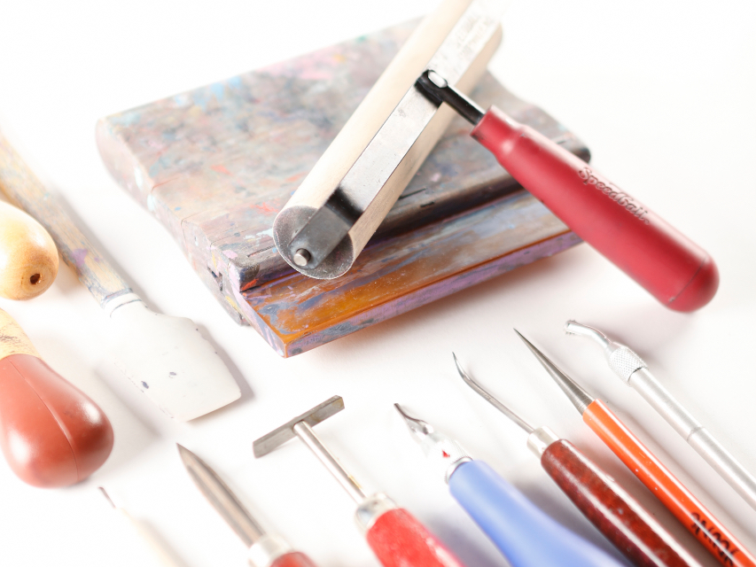 Photo of printmaking tools on a white surface.