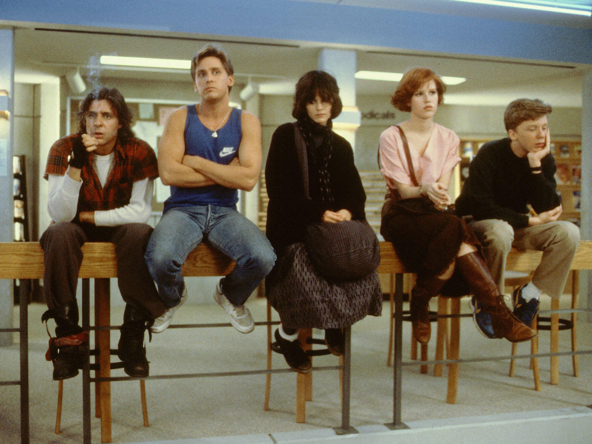 Still from the film The Breakfast Club depicting the five main characters sitting on a railing in a library.