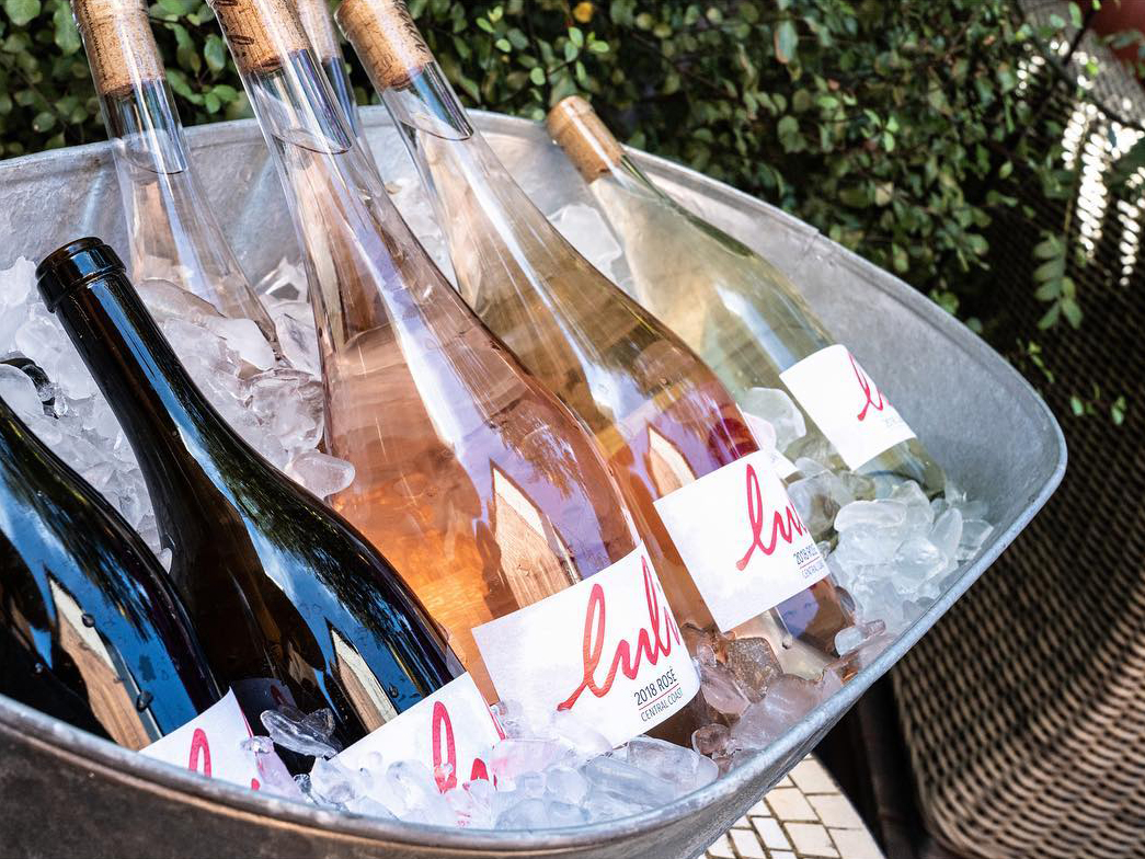 Photo of several Luli wine bottles sitting in a silver bowl with ice.