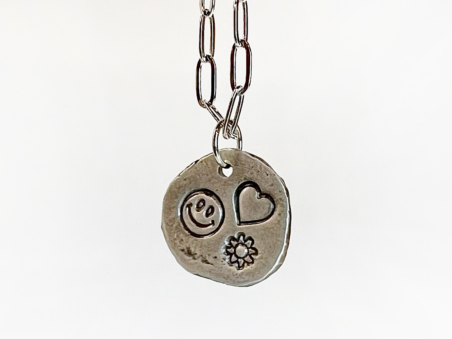 Photo of a silver pendant on a silver chain.