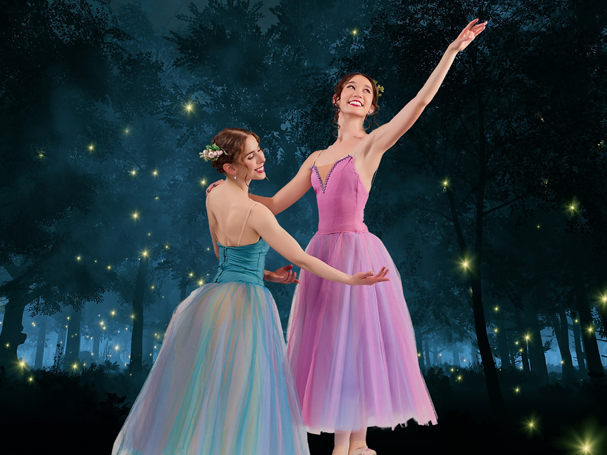 Photo of two female dancers in brightly colored leotards and tutus dancing in front of a nighttime forest background.