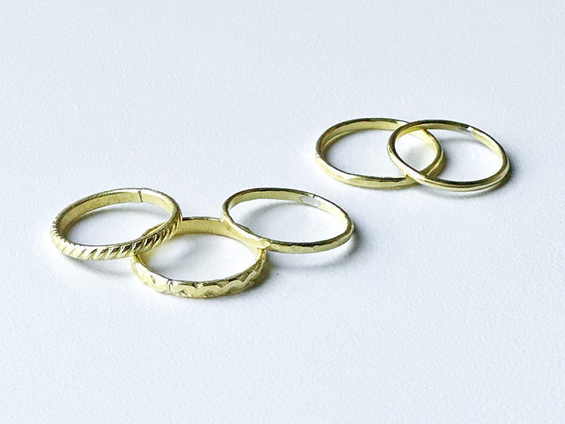 Photo of five handmade brass rings.