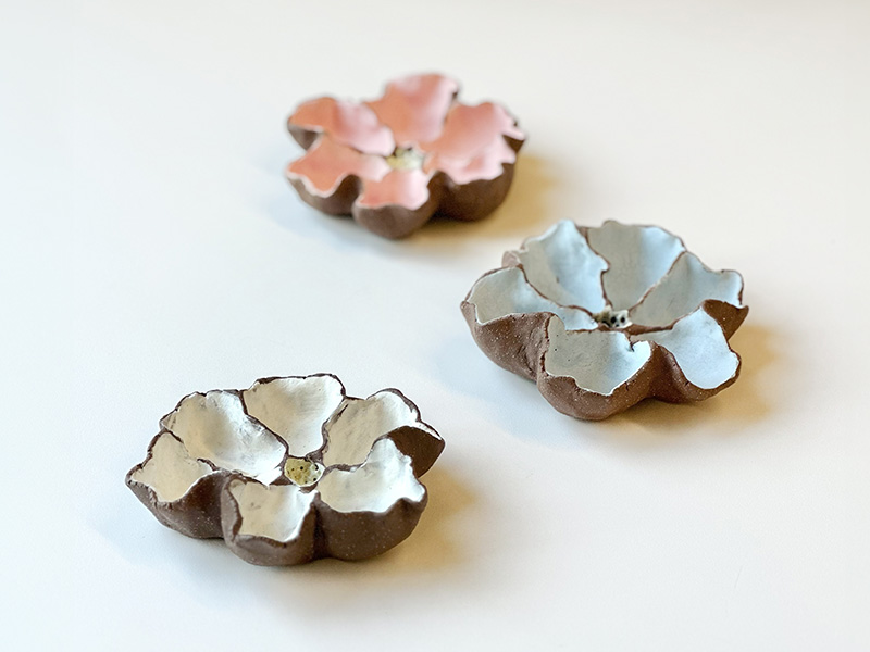 Photo of three small handmade ceramic dishes in the shape of flowers.