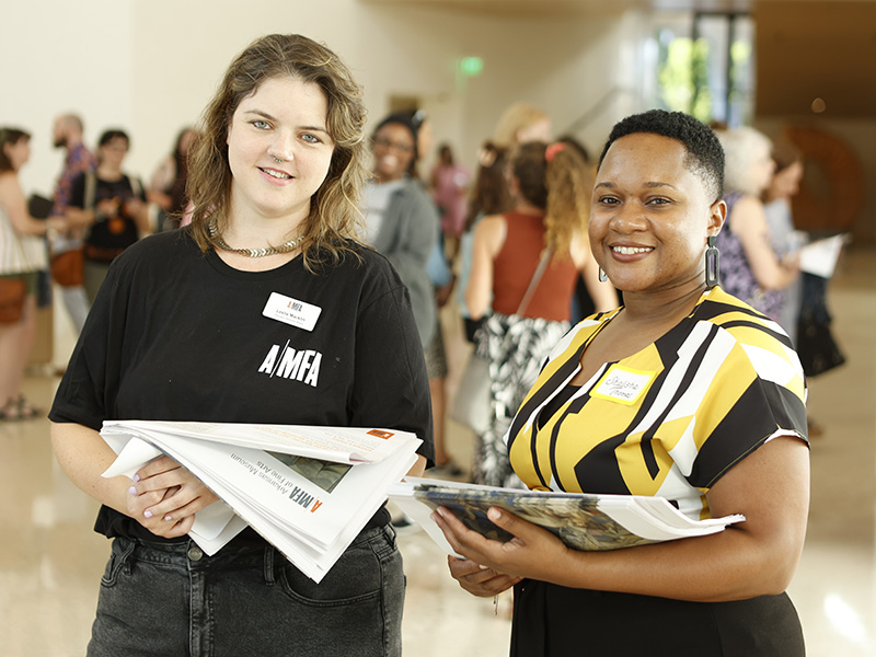 Photo of two educators smiling and wearing name tags in the Atrium of the Arkansas Museum of Fine Arts.