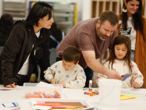 Photo of a mother, father, young boy, and young girl working on an art project in an art studio.