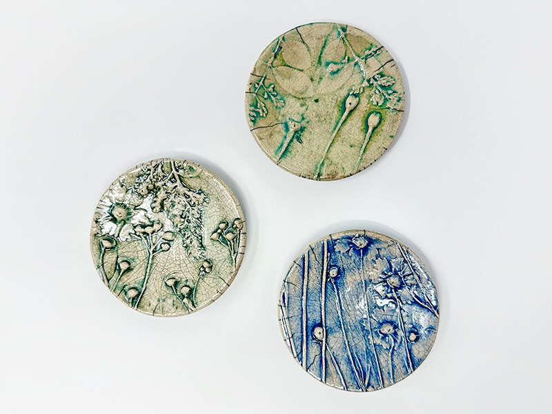 Photo of three small ceramic dishes decorated with leaves and flowers.